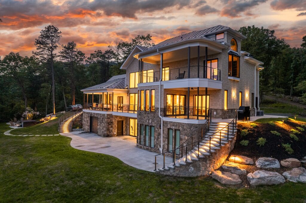 Luxury mountain cabin exterior with warm lighting at sunset at The Vale in Lost River Estates West Virginia, near Washington DC
