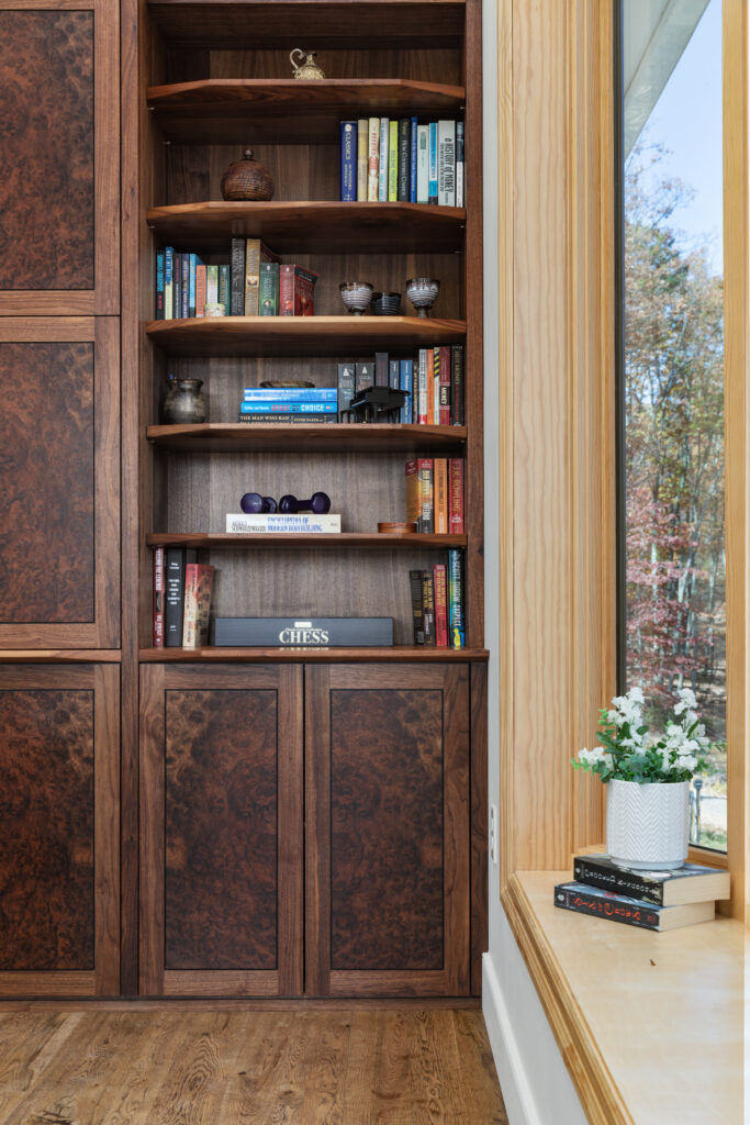 Built-in wooden bookshelf with books and decor at The Vale luxury cabin in Lost River West Virginia