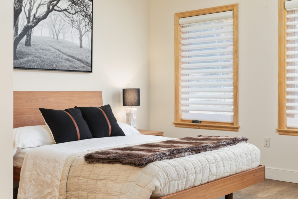Primary bedroom with queen bed and modern decor at The Vale luxury cabin in Lost River West Virginia
