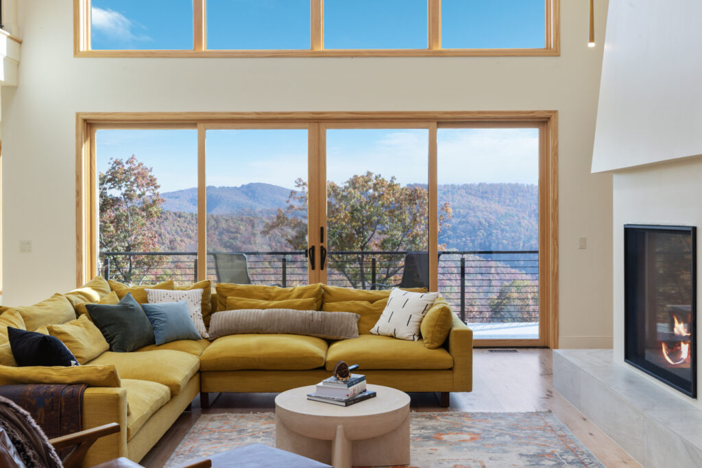 Ground floor living room with the large couch, fireplace and unobstructed views of the mountains in Lost River, West Virginia