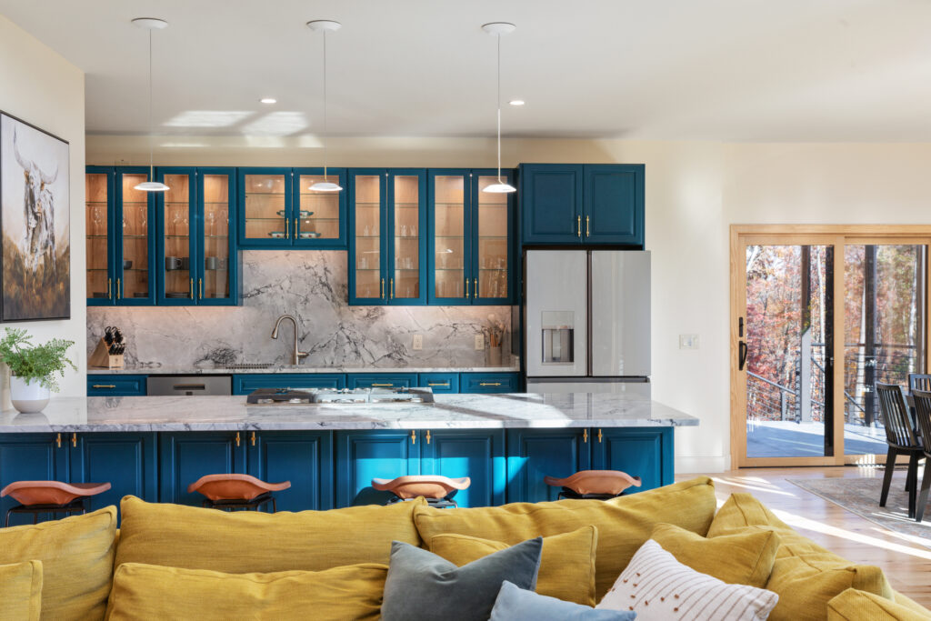 Open concept living room and luxury kitchen with granite island and blue cabinetry at The Vale in Lost River, West Virginia
