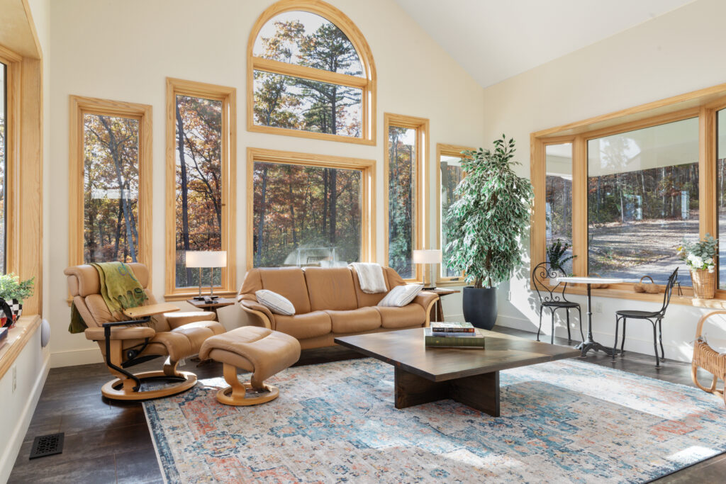 Spacious sunroom lounge with forest views at The Vale luxury cabin in Lost River West Virginia