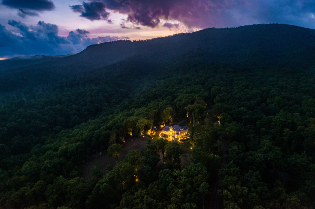 Aerial sunset view of The Vale luxury cabin surrounded by forest at Lost River Estates in Lost River West Virginia