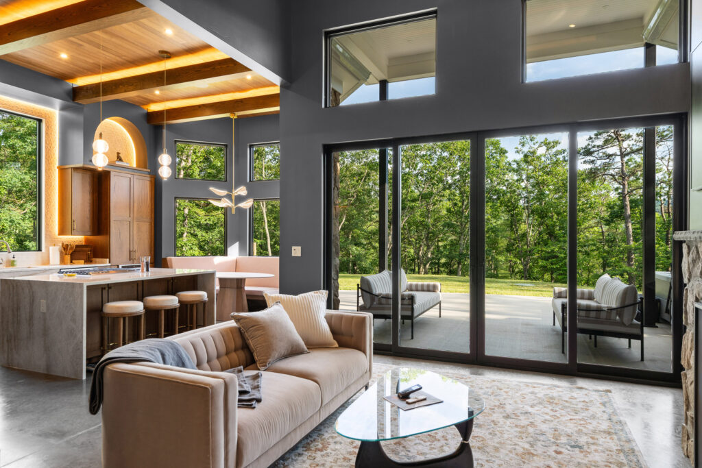 Living room at The Nook with the large floor to ceiling doors that look into the surrounding nature outside.
