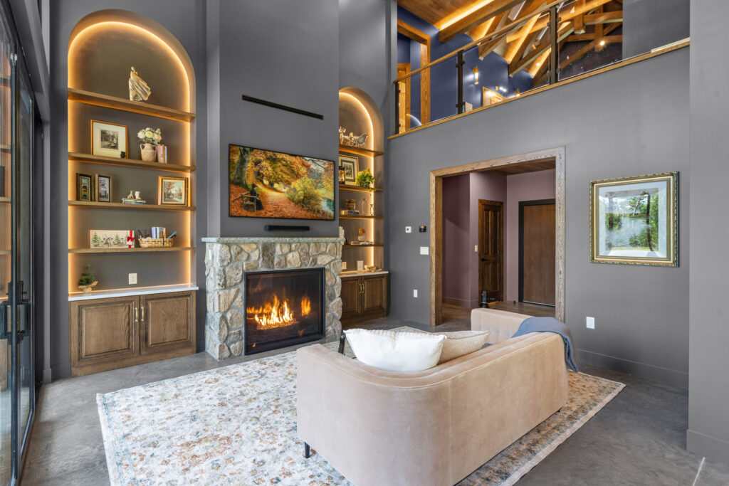 Main living room at The Nook with the frame tv, fireplace and grand bookcase s in Lost River, WV