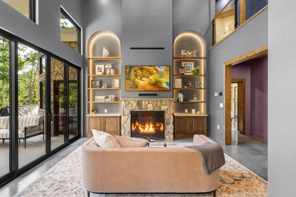Living room with curved sofa, fireplace, and arched built-in shelving at The Nook in Lost River, WV