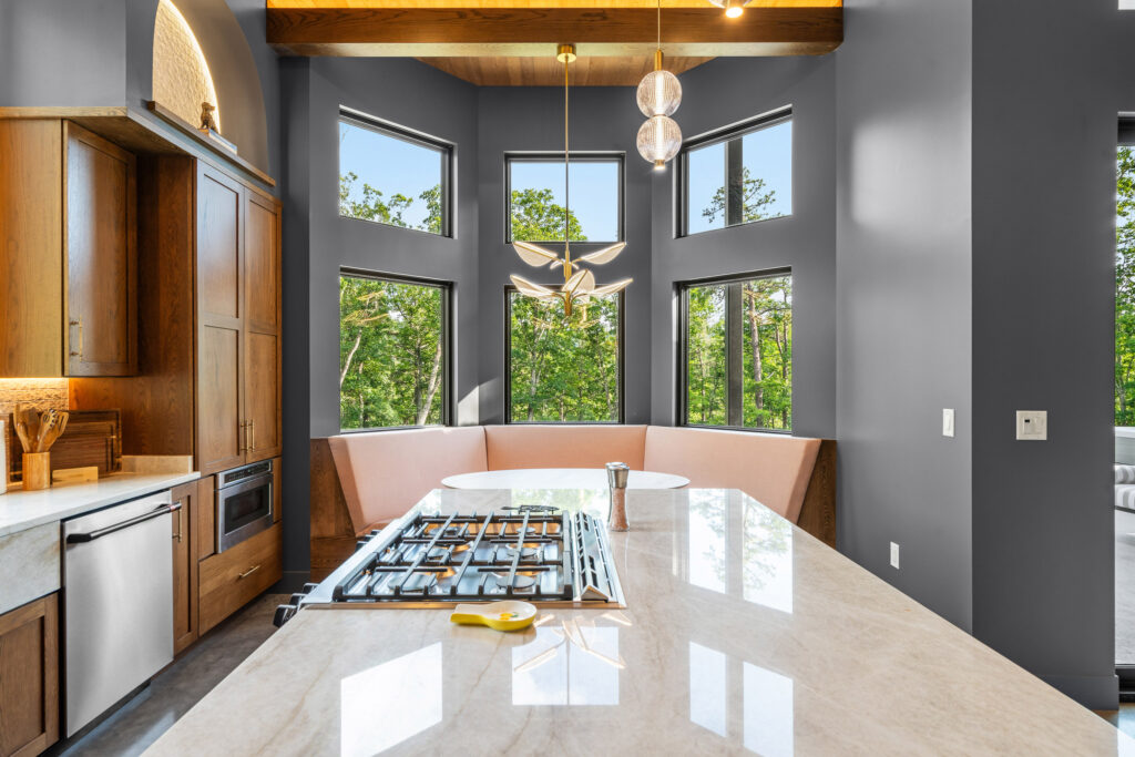 Dining area with sculptural chandelier and floor-to-ceiling forest views at The Nook