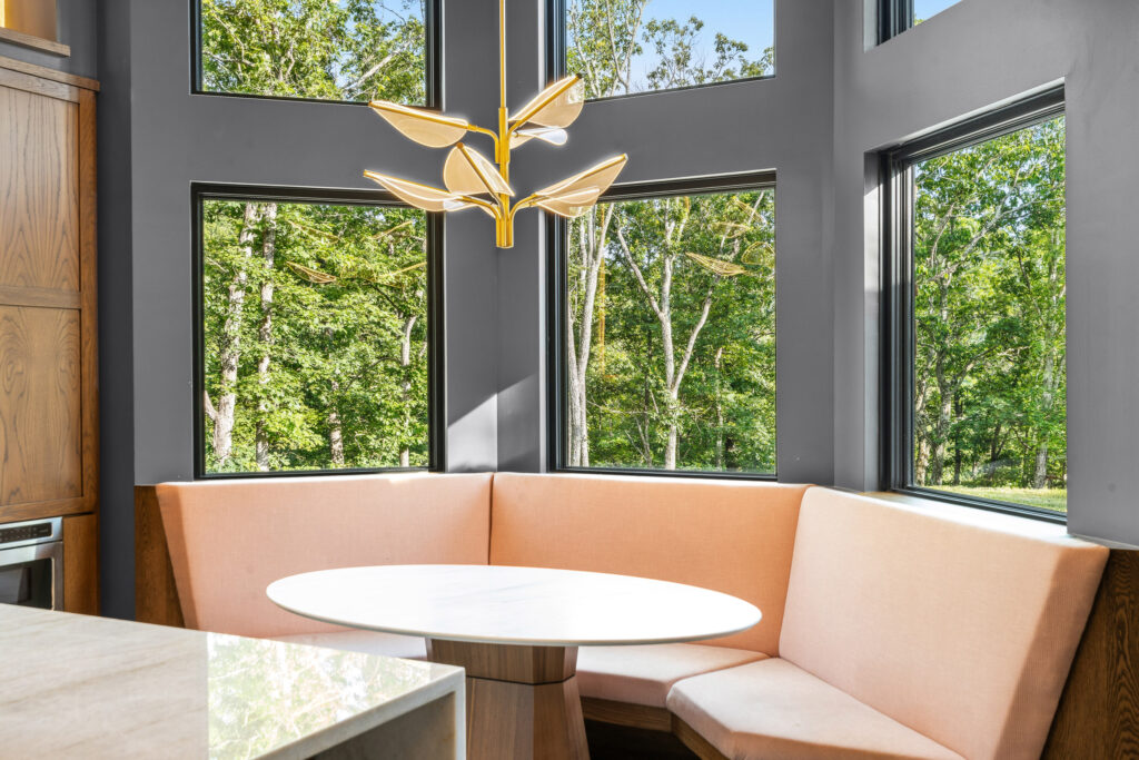 Open kitchen and dining space with island seating and large windows at The Nook