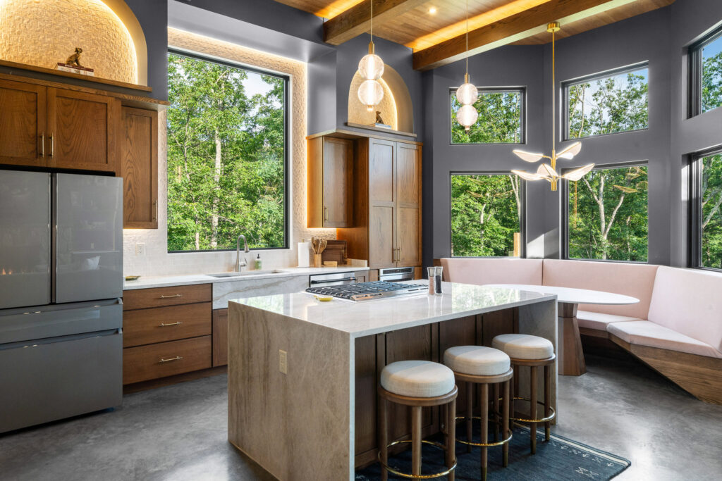 Dining nook with round table, built-in banquette, and modern chandelier at The Nook