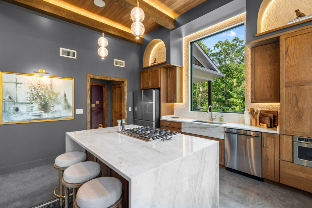 Kitchen with white waterfall-edge island, bar stools, and pendant lighting at The Nook