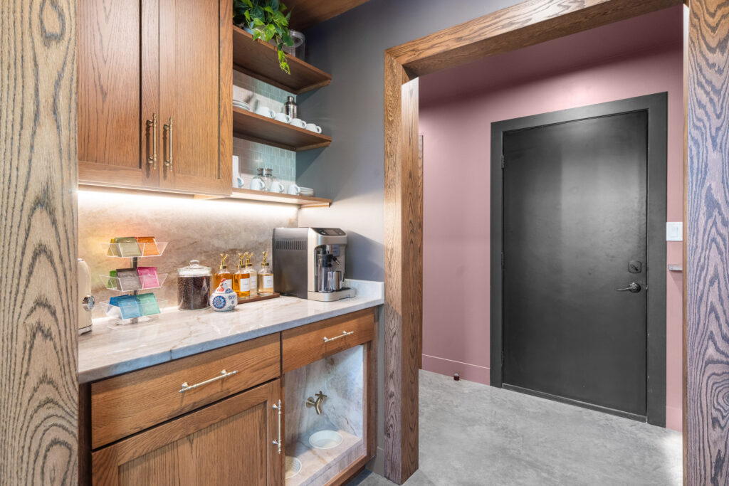 Kitchen corner with wood cabinetry and open shelving at The Nook