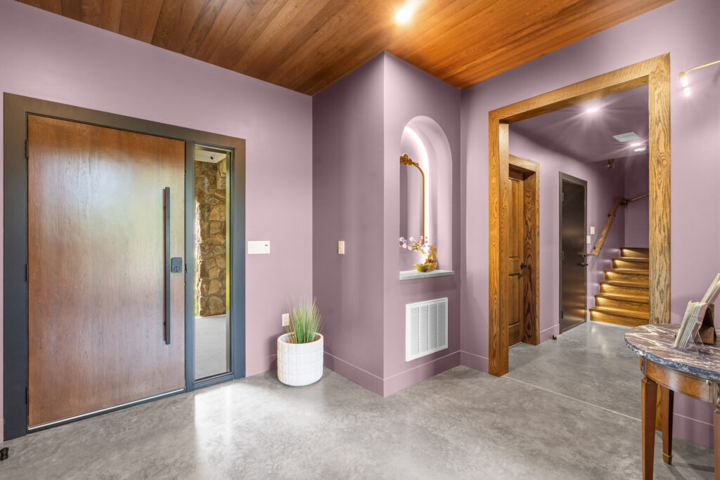 Hallway with mauve walls and warm wood flooring at The Nook
