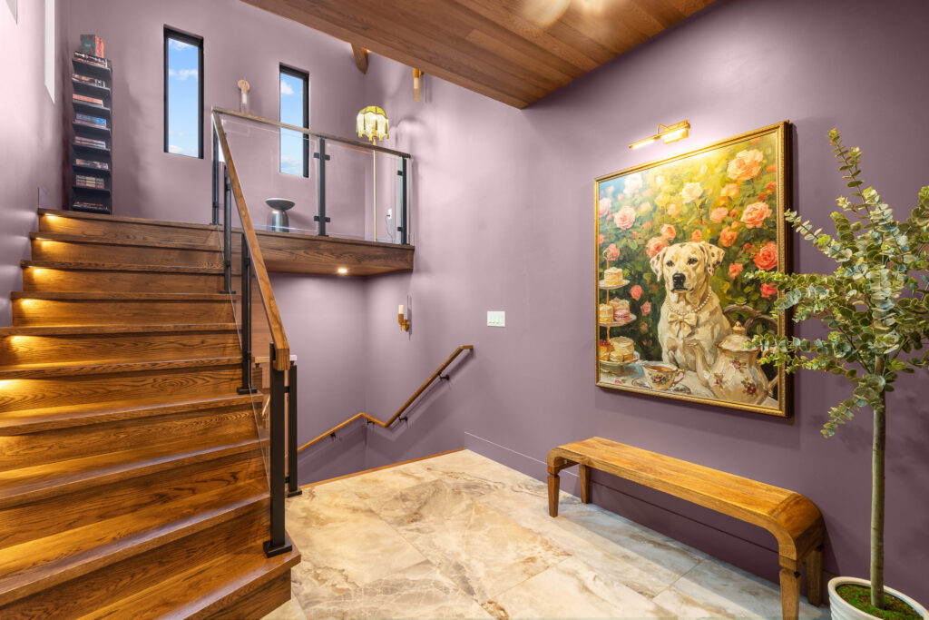 Wood staircase with mauve walls and framed artwork at The Nook