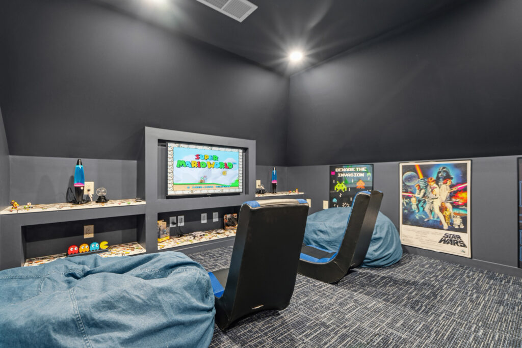 Arcade room with blue walls and wall-mounted TV, nintendo switch at The Nook luxury rental, in Lost River, WV