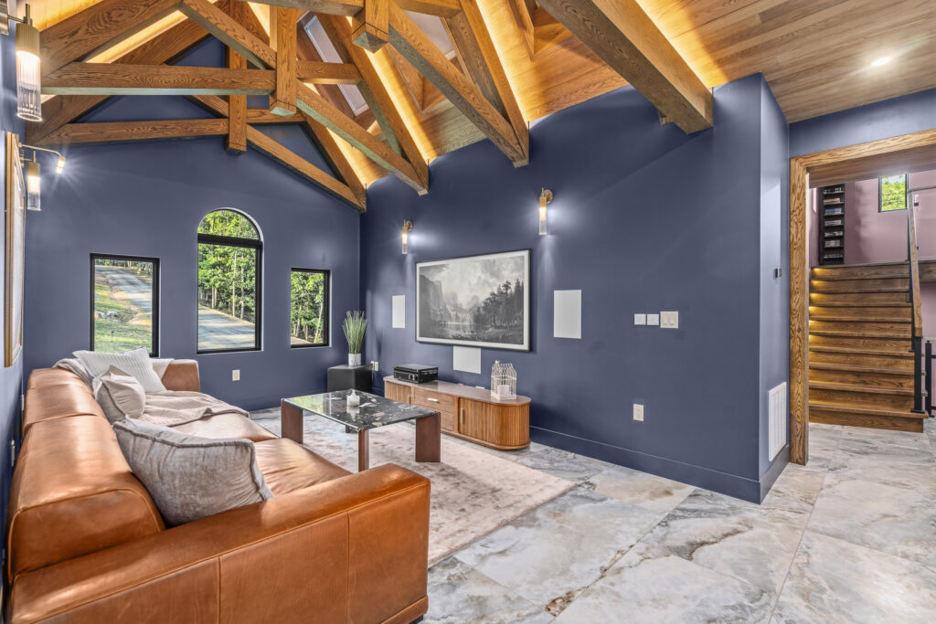 Sitting room with navy walls, vaulted ceiling, and arched windows at The Nook