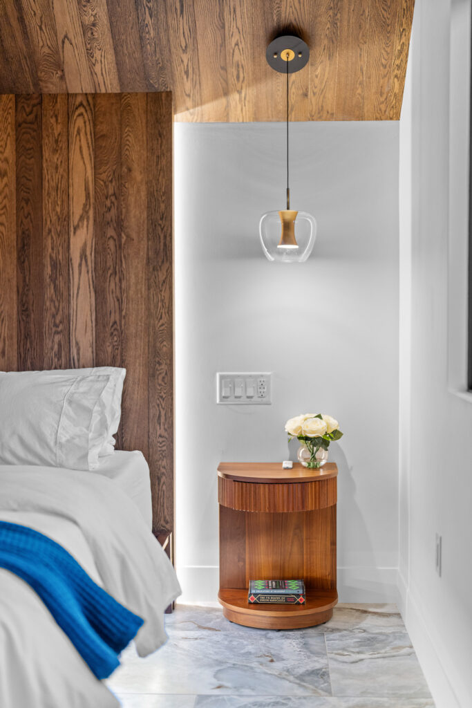 Nightstand in the upstairs bedroom, showing off white oak ceilings and built-in headboard with soft LED lighting at The Nook in Lost River, WV